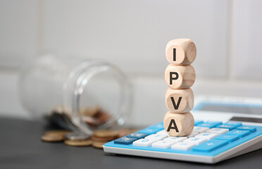 A sigla IPVA escrita em dados de madeira que estão sobre uma calculadora. Um pote de vidro com moedas do Brasil na composição. - obrazy, fototapety, plakaty