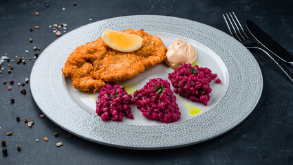 Fried pork fillet with rice in beetroot sauce.