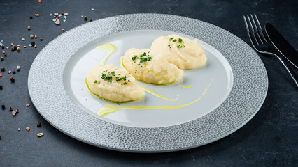 Garnish mashed potatoes with greens on plate.