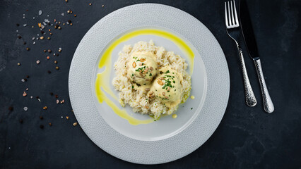 Pork meatballs with rice, milk sauce, seeds and herbs.