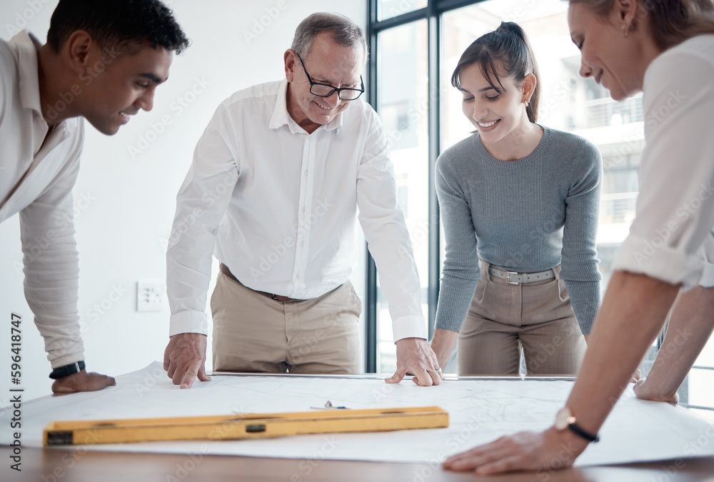 Poster going over the blueprints. cropped shot of four architects looking over blueprints in the office.