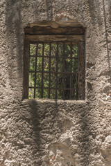 Window of an old house in a wall of adobes and quarry.