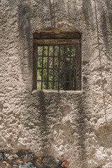 Window of an old house in a wall of adobes and quarry.