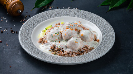 Dinner pork meatballs with buckwheat porridge and sauce.