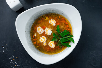 Vegetable soup with potatoes, carrots, onion, sour cream and parsley.