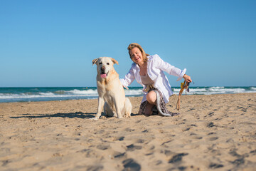 Middle-aged woman and her dog look at the camera at the beach