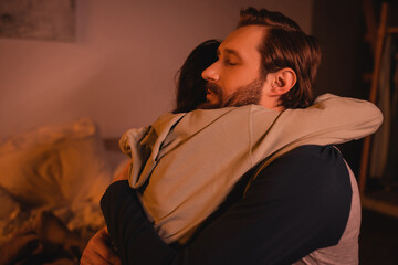 Fototapeta na wymiar caring man hugging and calming down girlfriend at home in evening.