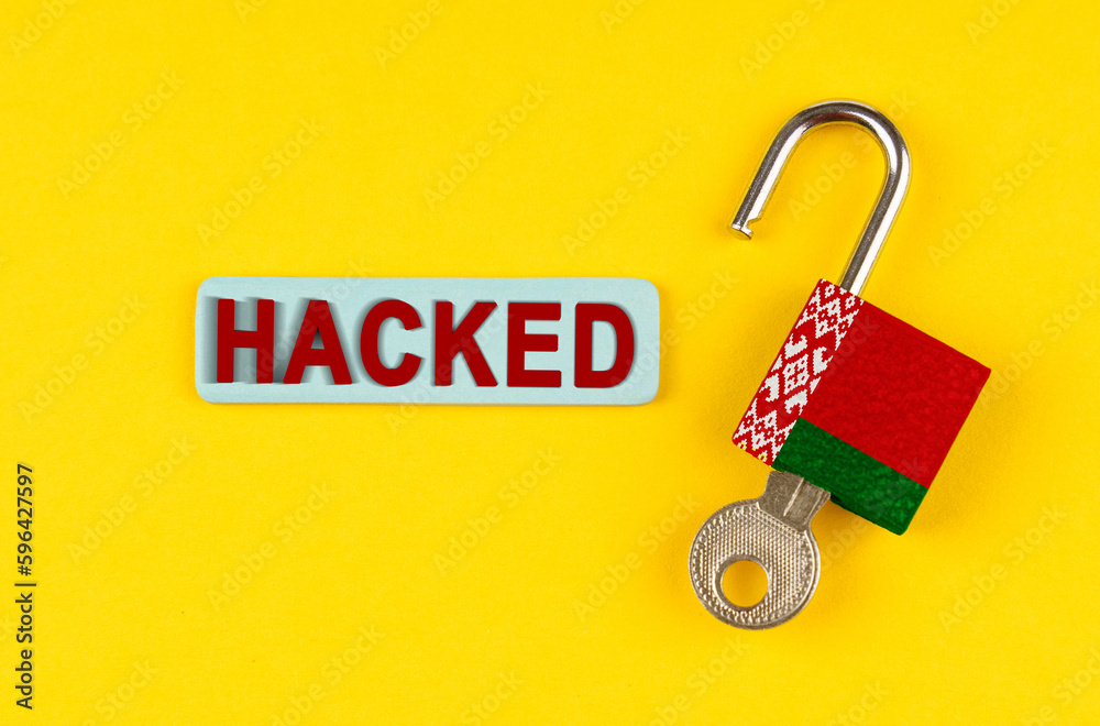Poster on the yellow surface is an open lock with a key and a sticker with the inscription - hacked