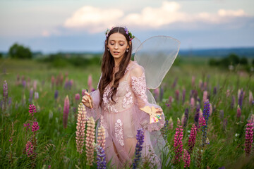 Beautiful romantic girl on nature field of flowers. Photo of sensual woman.