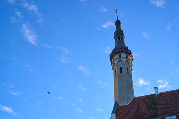 Obraz premium Airplane flying over Tallinn Town Hall, Tallinn, Estonia