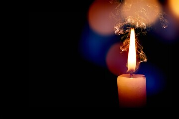 Candle flame with smoke on dark room background
