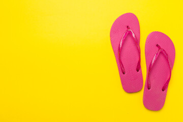 Bright flip flops on color background, top view