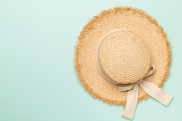 Stylish straw hat on color background, top view