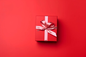 Gift box with satin ribbon and bow on red background. Holiday gift with copy space. Birthday or Christmas present, flat lay, top view. Christmas giftbox concept