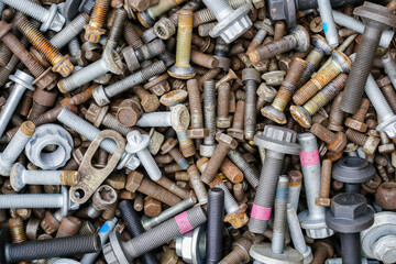 Background with many new and used bolts and nuts of various sizes and colors