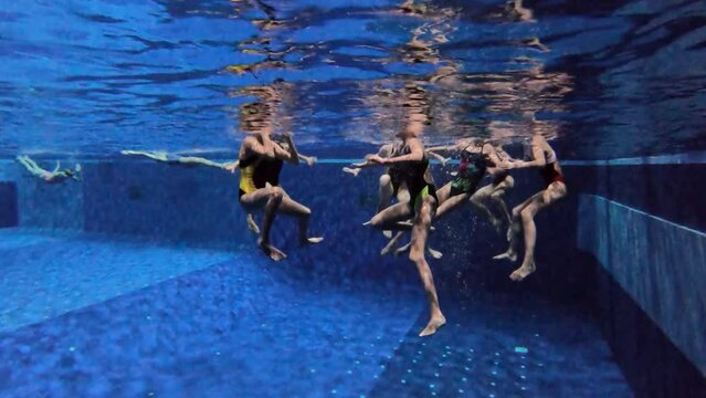 Synchronized swimming junior team underwater training in the swimming pool