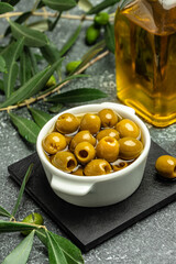 Branch with olives and a bottle of olive oil on dark background. top view. place for text
