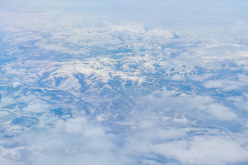 Aerial view of the Siberian hills and mountains covered with snow in the tundra. Siberia, Far East...