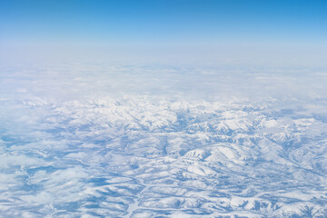 Aerial view of the Siberian hills and mountains covered with snow in the tundra. Siberia, Far East...