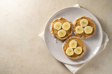 Rice cakes with banana and peanut butter, healthy protein snack, top view, copy space