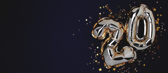 Banner with number 20 golden foil balloons with stars confetti on a black background. Place for...