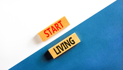 Start living symbol. Concept words Start living on beautiful wooden block. Beautiful white and blue...