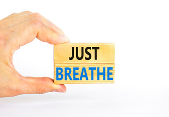 Just breathe and psychological symbol. Concept words Just breathe on beautiful wooden block. Beautiful white background. Businessman hand. Business psychological and Just breathe concept. Copy space