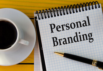 PERSONAL BRANDING - words on a white sheet on a yellow wooden background with a pen and a cup of coffee