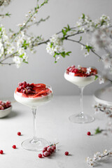 Italian panna cotta dessert with strawberry sirup and fresh strawberries on gray background.