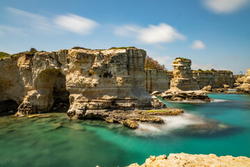 Fototapeta premium Faraglioni of Sant'Andrea, Puglia. Evocative spectacle, on a cliff overlooking the sea with caves, inlets and wild animals, in short, a world to discover. Long exposure during a windy day.