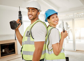 Lets get renovating. Shot of two construction workers standing back to back in a house and holding...