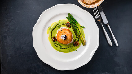 Breaded shrimp balls with asparagus, tomatoes and green sauce.