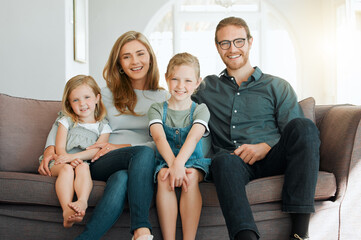 This is our little family. Shot of young family sitting on the sofa at home together and bonding.