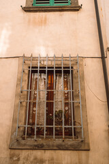 Fototapeta na wymiar Old window with ornamented metal lattice, Pisa Italy.High quality photo