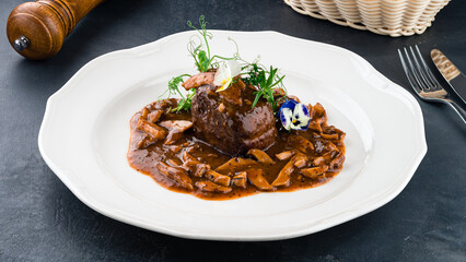 Fried beef fillet steak with mushrooms and greens.