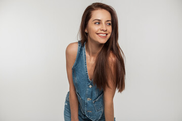 Happy beautiful young woman model with cute smile in trendy fashion vintage denim clothes having fun and posing on white background