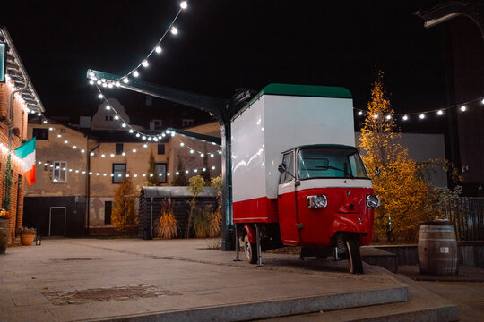 Antique bead car in the color of the Italian flag near the city street cafe at night. High quality photo - Powered by Adobe