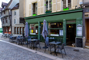 Old street with old houses and tables of cafe in a small town Chartres, France
