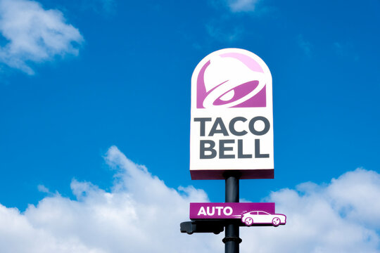 Finestrat, Spain - March 2, 2023: Taco bell logo sign on pole signboard against blue sky. Taco Bell is American-based chain of fast food restaurants, witch serve variety of Mexican-inspired foods
