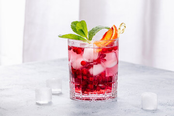Cold refreshing summer drink with lingonberry and oranges