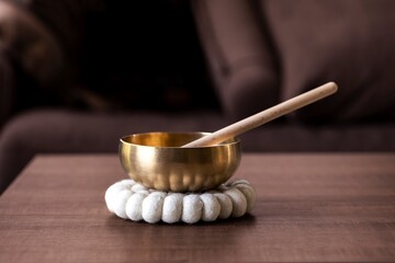 A tibetan singing bowl, also called a himalayan bowl, with a mallet standing in it to make a...
