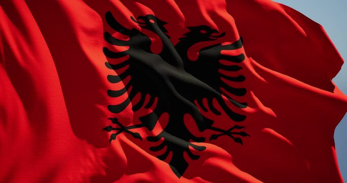 Close-up of the national flag of the republic of albania flutters in the wind on a sunny day , 4k slow motion