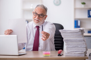 Obraz premium Old male employee and too much work in the office