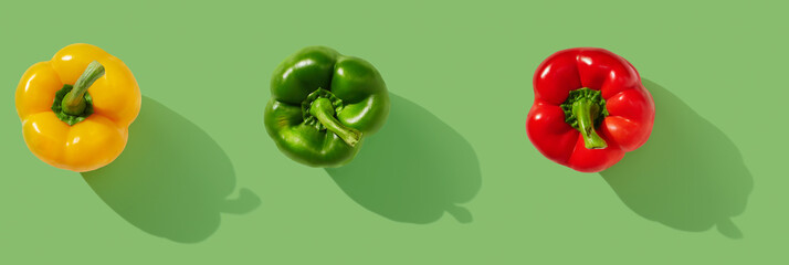 Yellow, red, green pepper on green pastel background