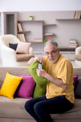 Old man with many pillows at home