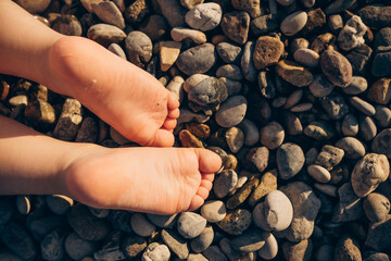 Little child's bare feet  on the beach