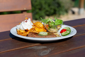 Mouthwatering steak with potato edges and sour creme with tempting, culinary flavors