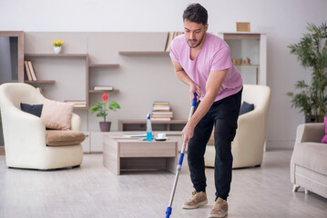 Young male contractor cleaning the house