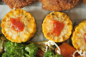 Ears of corn baked with herbs on white baking paper