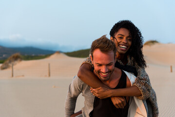 Laughing at piggyback having fun at beach